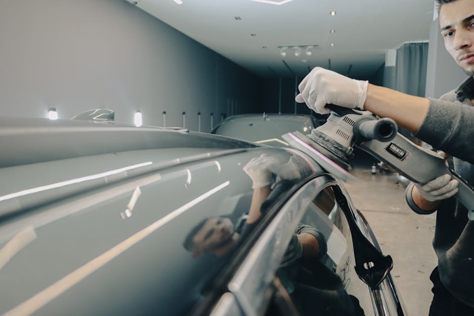 Professional auto detailer carefully working on vehicle